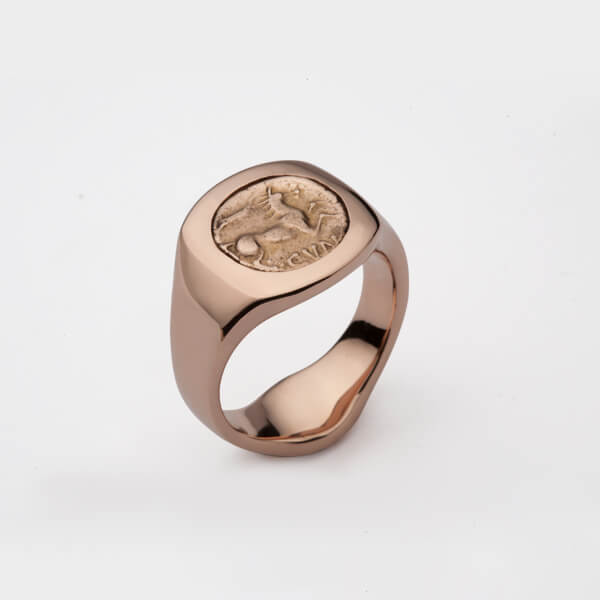 A bespoke rose gold signet ring with a Celtic coin set in the centre.